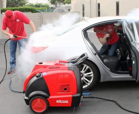 Two mobile car wash operators cleaning a car interior and exterior with the Optima Steamer DMF