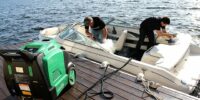 2 people cleaning a boat interior on the dock with an Optima Steamer