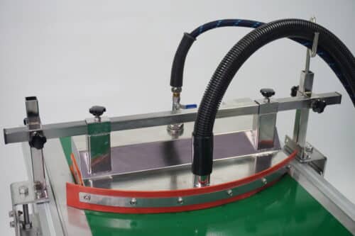 Vacuum Conveyor Belt Cleaning Tool attached to a green conveyor belt