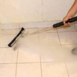 Cleaning tile grout with a special steam mop squeegee