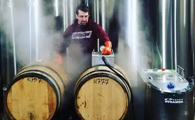 Craft Brewery staff person using Steamericas' Wine Barrel Tool to steam sanitize 1 or 2 wine barrels being used for the production of craft beer