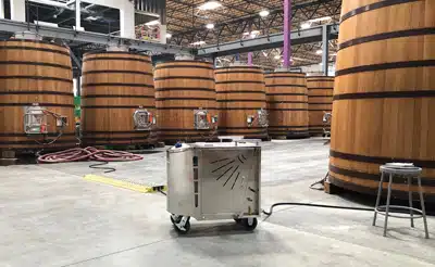 Optima Steamer SE by Steamericas displayed in front of a warehouse-full of large foeders used by Lagunitas Brewing Company for cleaning and sanitizing